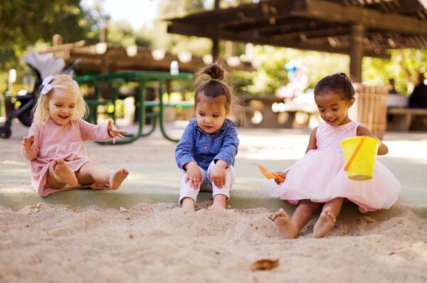 3 petites filles en train de jouer dans un aire de jeux