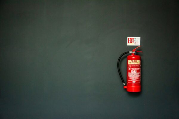 red fire extinguisher on gray wall